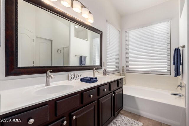 full bathroom with double vanity, a sink, a bath, and tile patterned floors