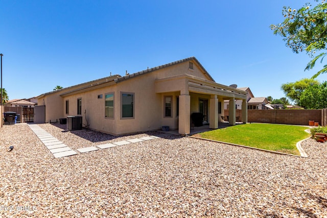 rear view of house featuring cooling unit, a patio, a fenced backyard, stucco siding, and a lawn