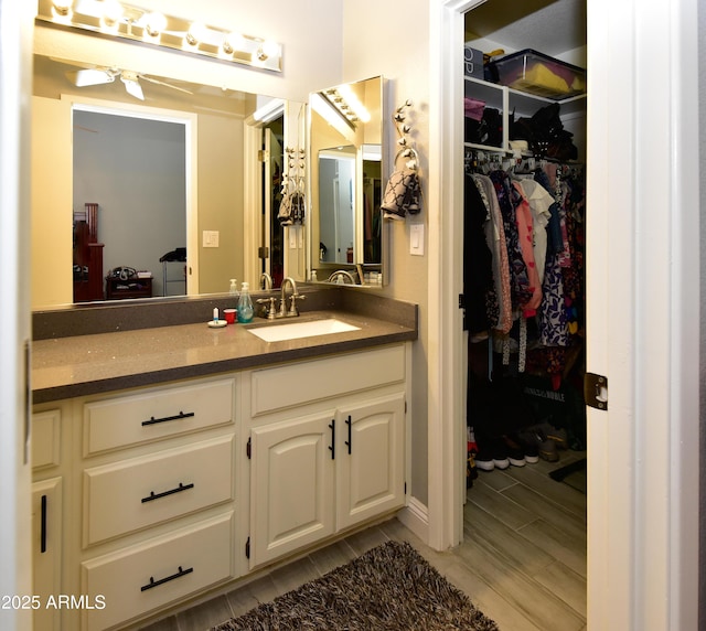 7916 E Naranja Ave, Mesa, AZ 85209 - bathroom featuring wood tiled floors, vanity, a walk in closet, and a ceiling fan