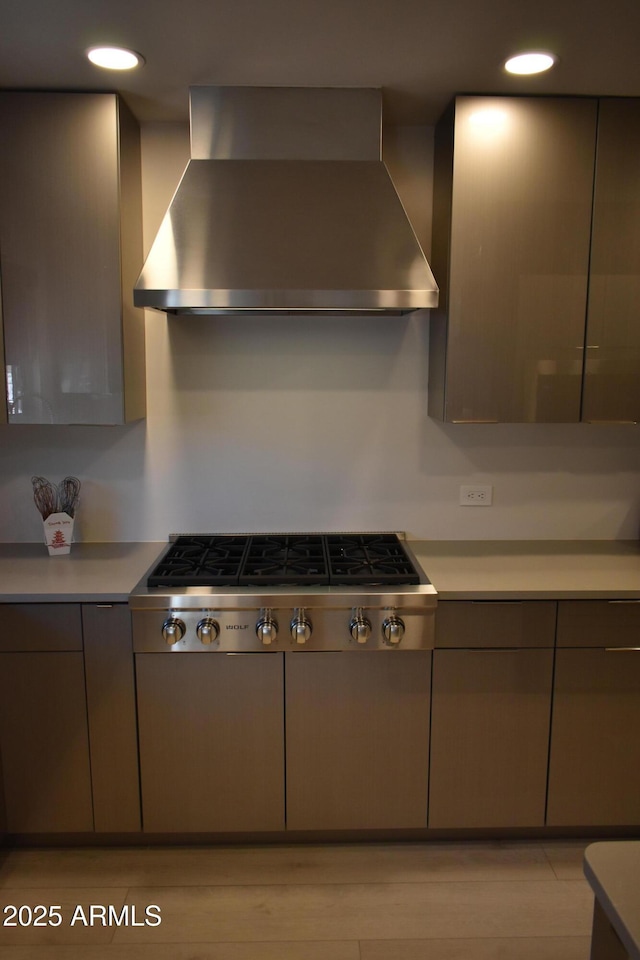 kitchen with wall chimney exhaust hood, stainless steel gas cooktop, light countertops, and recessed lighting