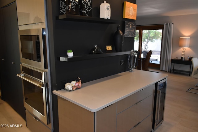 kitchen featuring oven, wine cooler, built in microwave, light wood-style flooring, and modern cabinets