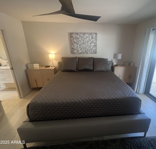bedroom featuring light wood finished floors and connected bathroom