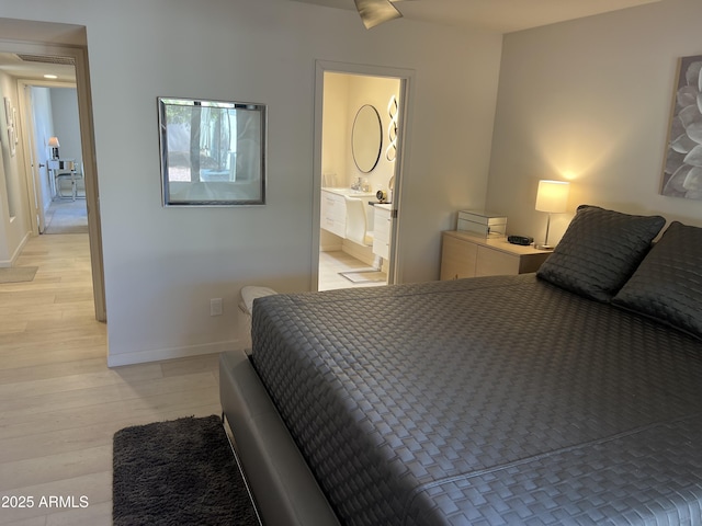 bedroom with light wood-type flooring, visible vents, and baseboards