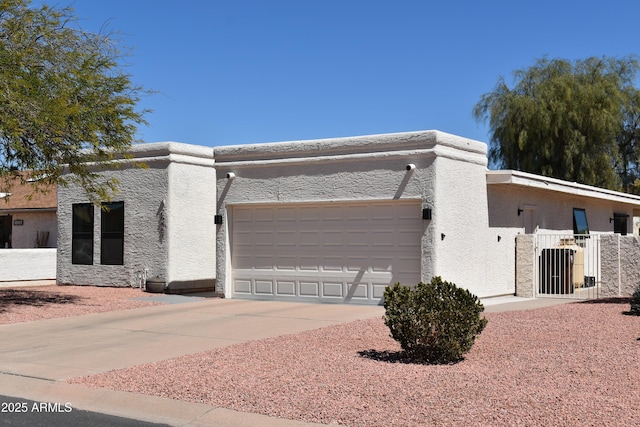 view of side of property with stucco siding, driveway, fence, and a garage