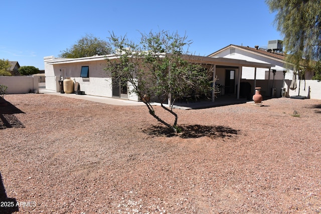 rear view of property featuring stucco siding, fence, a patio, and cooling unit