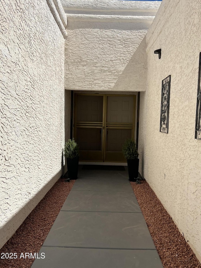 entrance to property featuring stucco siding
