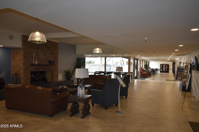 living area featuring light tile patterned flooring, a brick fireplace, and recessed lighting