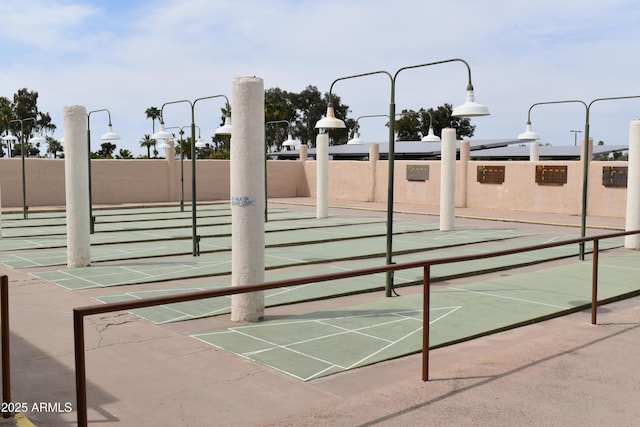 view of home's community with fence and shuffleboard