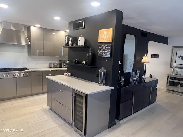 kitchen with modern cabinets, wall chimney exhaust hood, beverage cooler, and gray cabinets