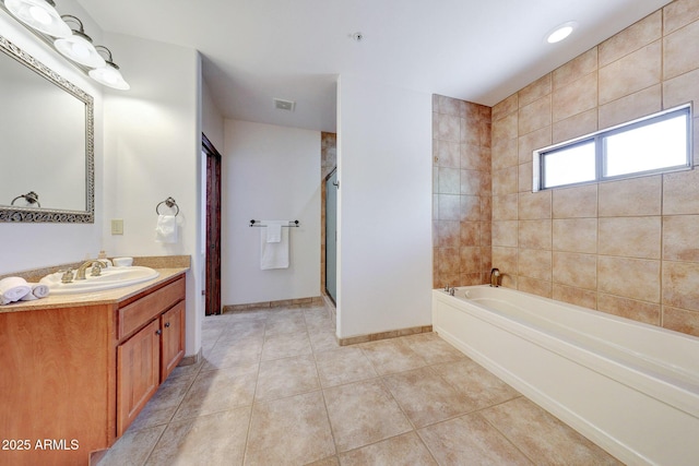 bathroom featuring tile patterned flooring, vanity, a bath, a shower stall, and baseboards