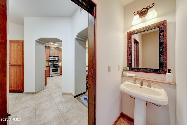 bathroom with tile patterned flooring, tasteful backsplash, and baseboards