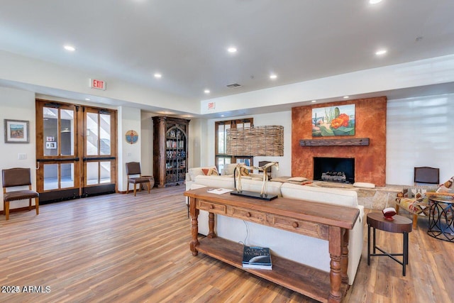 living area featuring a fireplace, wood finished floors, and recessed lighting