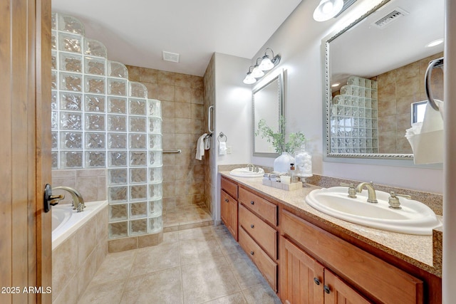 full bath with walk in shower, tile patterned flooring, double vanity, and a garden tub