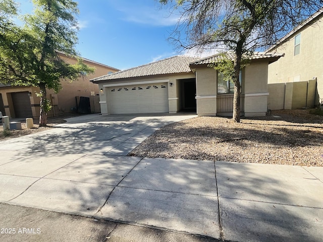 ranch-style house featuring a tile roof, a garage, fence, concrete driveway, and stucco siding