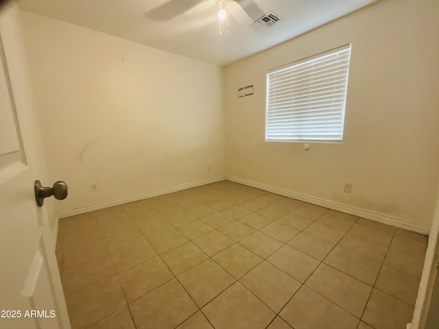 empty room with visible vents, baseboards, ceiling fan, and light tile patterned flooring