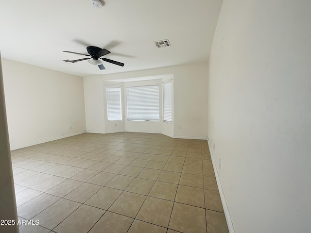 spare room with light tile patterned floors, baseboards, ceiling fan, and visible vents