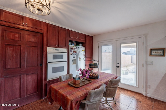 tiled dining room featuring french doors and a chandelier