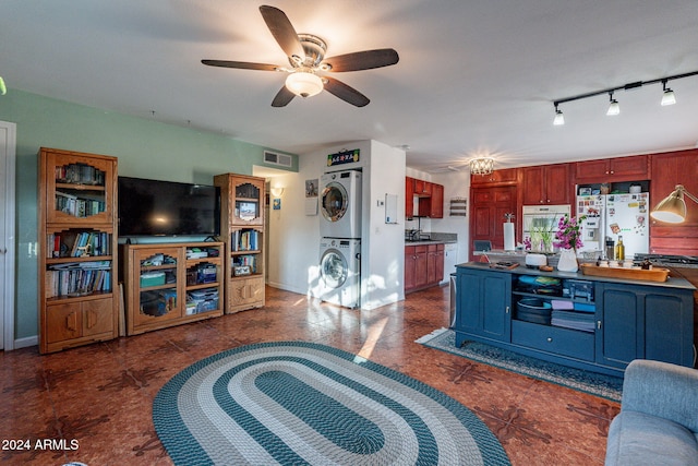 living room featuring stacked washer / dryer and ceiling fan