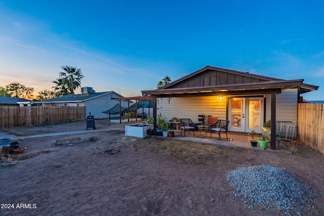 back house at dusk with a patio