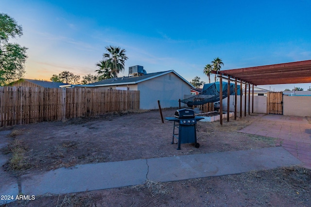 yard at dusk featuring central AC