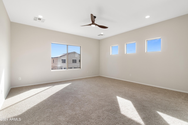 carpeted spare room with ceiling fan