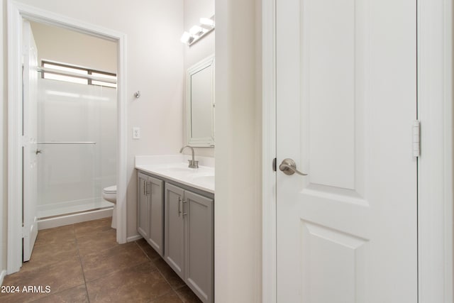 bathroom with vanity, toilet, walk in shower, and tile patterned flooring