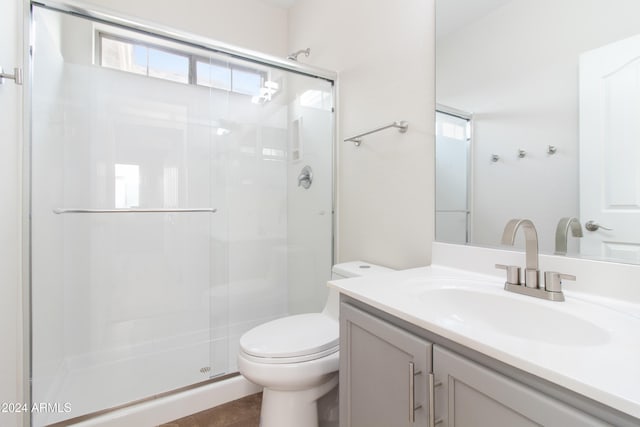 bathroom with vanity, tile patterned floors, toilet, and an enclosed shower