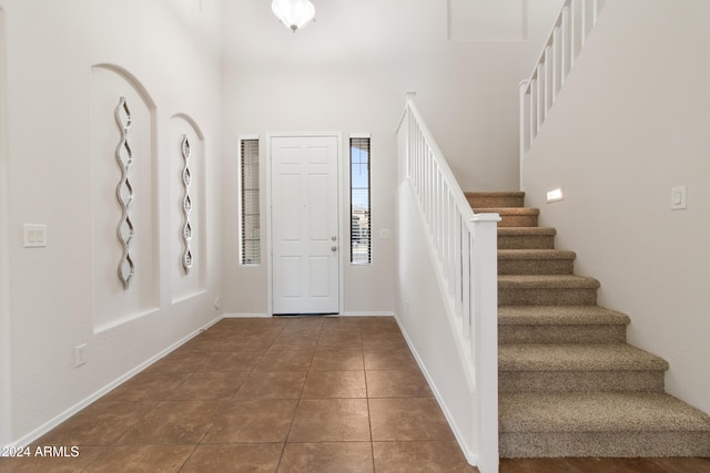 entryway with dark tile patterned floors