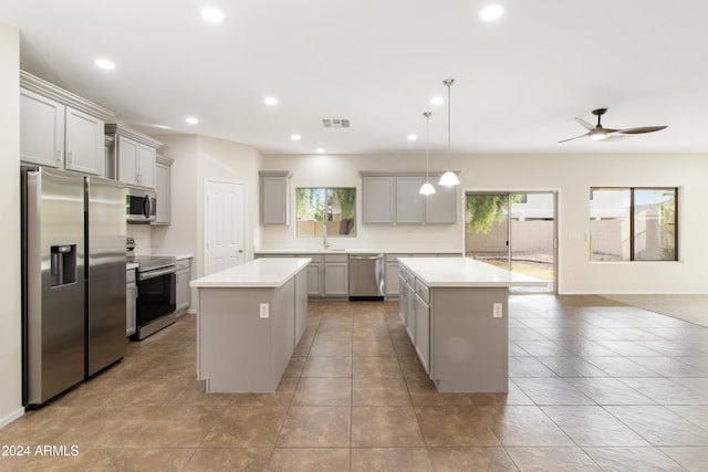 kitchen featuring sink, stainless steel appliances, a center island, and gray cabinets