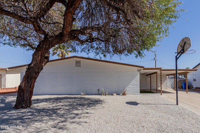 view of front of house with an attached carport and brick siding