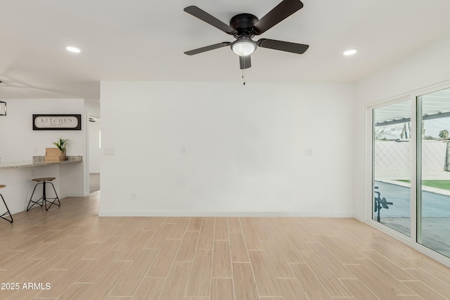 unfurnished room with light wood finished floors, baseboards, and recessed lighting