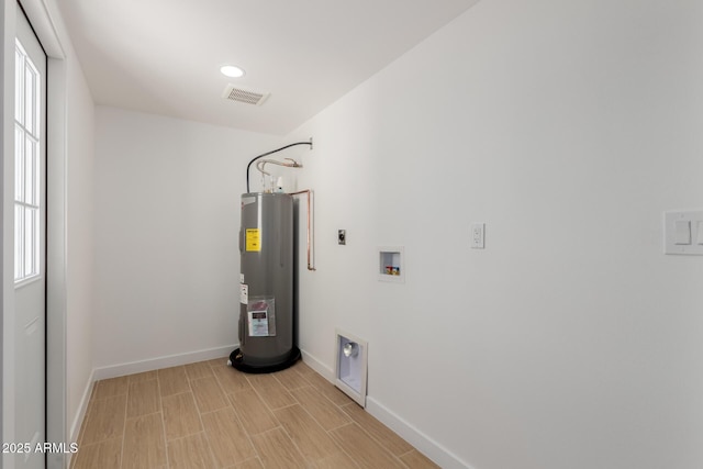 utility room featuring visible vents and electric water heater