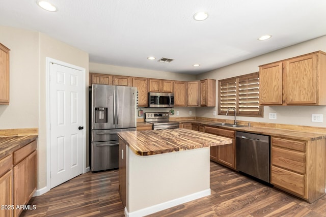 kitchen featuring wood counters, appliances with stainless steel finishes, a sink, and visible vents