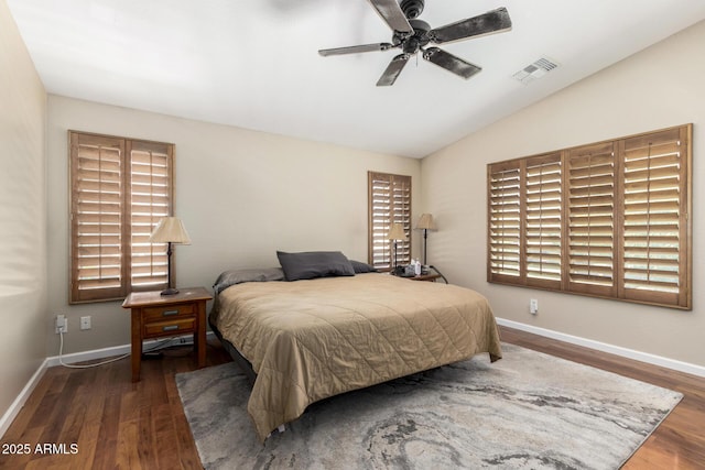 bedroom with baseboards, visible vents, and wood finished floors