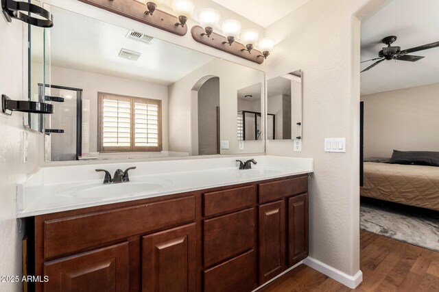 ensuite bathroom featuring ensuite bathroom, a sink, wood finished floors, and visible vents