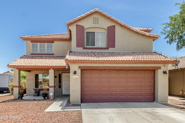 mediterranean / spanish home with concrete driveway, a tiled roof, an attached garage, and stucco siding