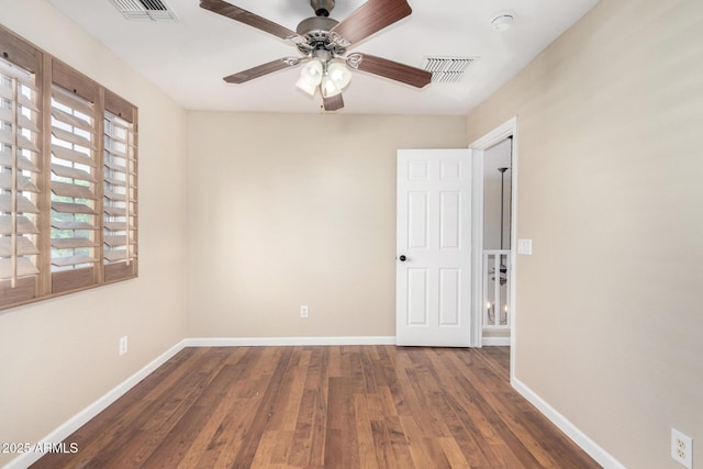 unfurnished room featuring baseboards, a ceiling fan, wood finished floors, and visible vents