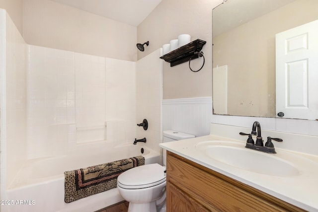 full bathroom with vanity, toilet, washtub / shower combination, and a wainscoted wall