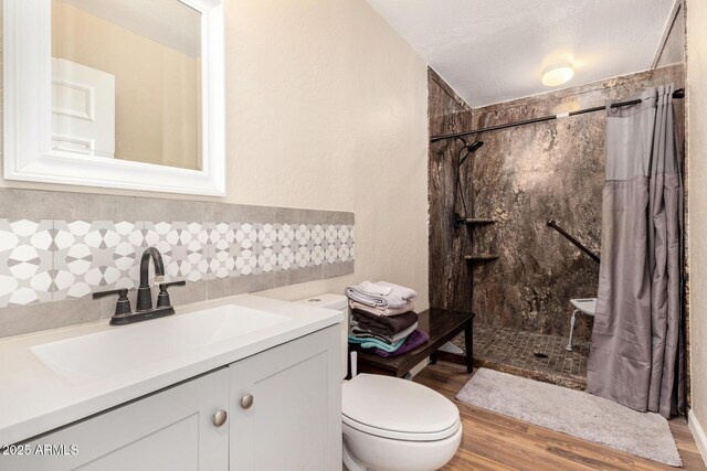 full bathroom with walk in shower, vanity, toilet, wood finished floors, and backsplash