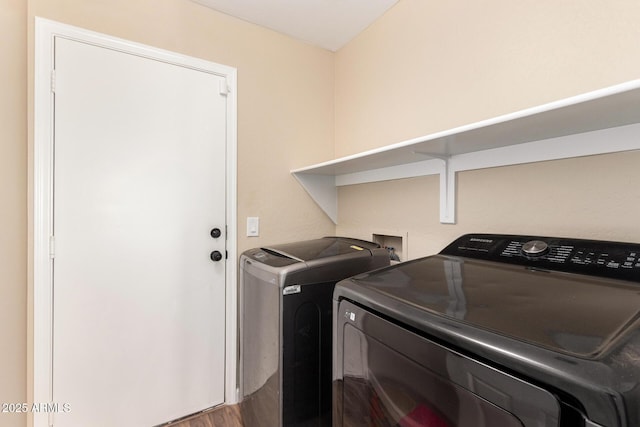 clothes washing area with independent washer and dryer, laundry area, and dark wood-style floors