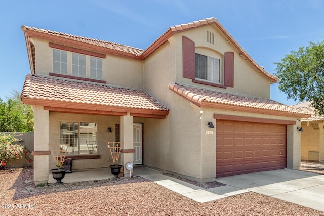 mediterranean / spanish home with stucco siding, driveway, a tile roof, and a garage
