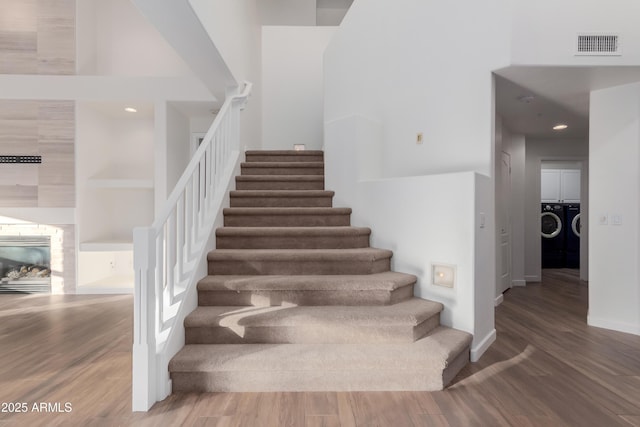 14056 E Desert Cove Ave, Scottsdale, AZ 85259 - stairs featuring independent washer and dryer, wood finished floors, a towering ceiling, a fireplace, and baseboards