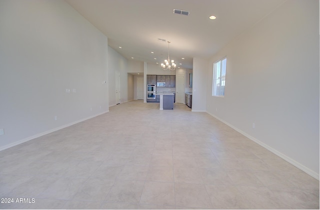 unfurnished living room with lofted ceiling, a notable chandelier, and light tile patterned floors