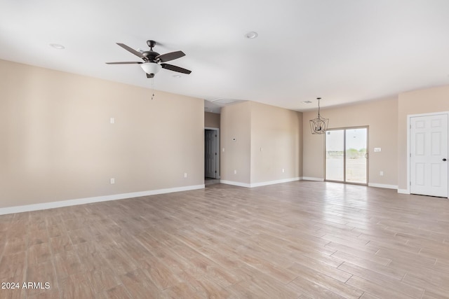 unfurnished room with ceiling fan with notable chandelier and light hardwood / wood-style flooring