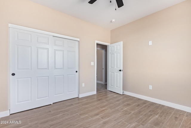 unfurnished bedroom featuring ceiling fan, light wood-type flooring, and a closet