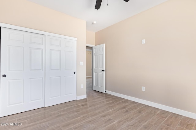 unfurnished bedroom with ceiling fan, light wood-type flooring, and a closet