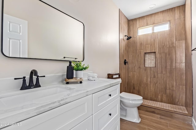 bathroom with wood-type flooring, vanity, toilet, and walk in shower