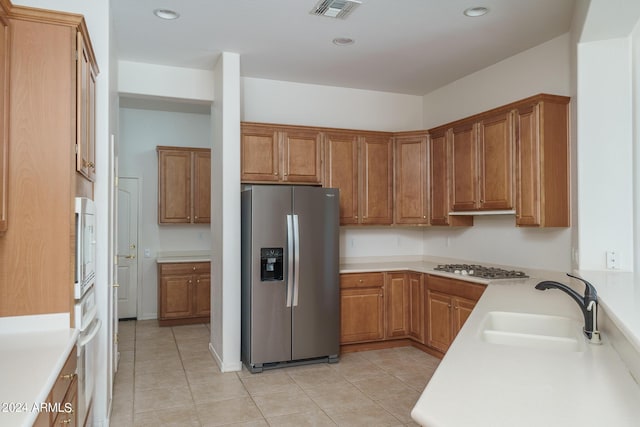 kitchen with sink, light tile patterned floors, and stainless steel appliances