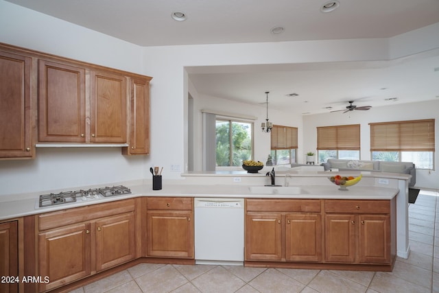 kitchen featuring sink, gas cooktop, dishwasher, hanging light fixtures, and a wealth of natural light