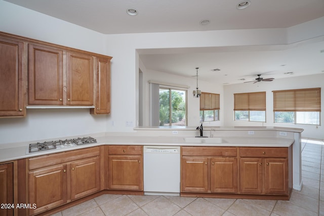 kitchen with decorative light fixtures, dishwasher, sink, light tile patterned floors, and gas cooktop